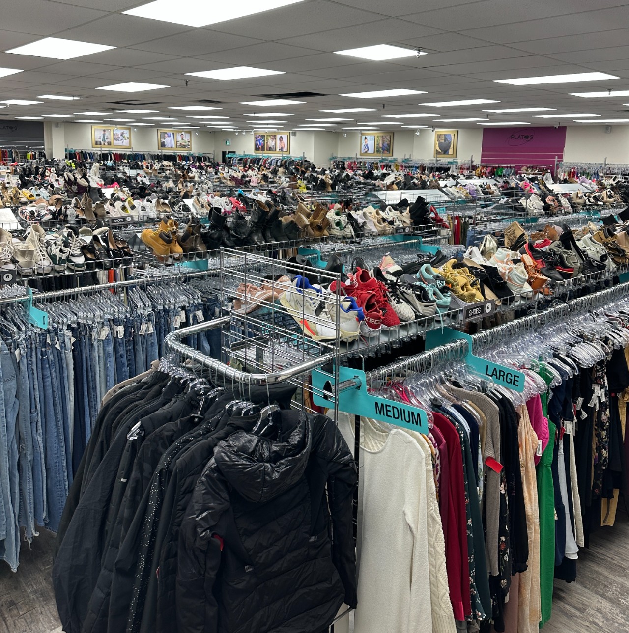 Picture of Plato's Closet London interior. Racks with clothes and shoes.